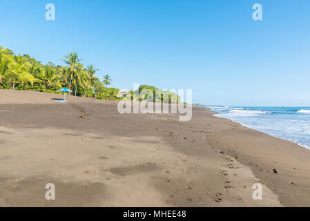 Sonnenschirm und Handtuch an der Playa Hermosa de Costa Rica - Pazifikküste Stockfoto