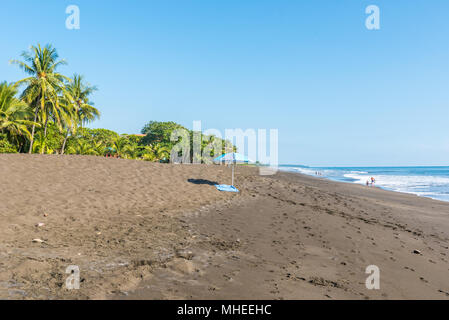 Sonnenschirm und Handtuch an der Playa Hermosa de Costa Rica - Pazifikküste Stockfoto