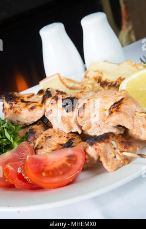 Ein traditionelles türkisches Gericht Hühnchen Shish Kebab, tavuk şiş Kebap, serviert mit frischem Salat, Tomaten und türkische Fladen. Stockfoto