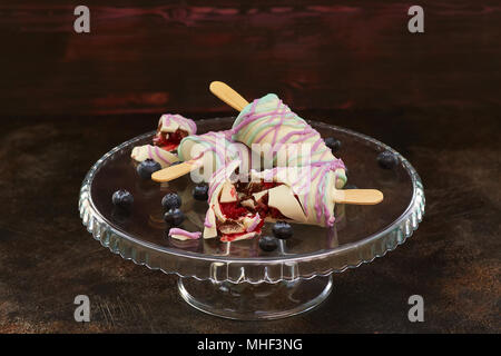 Süße Bonbons mit Heidelbeere in Form von Eis auf dunklem Hintergrund Stockfoto