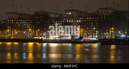 Nacht Blick auf die Themse, London mit einer Party Boot und MoD (Ministerium für Verteidigung) Gebäude, die RAF Memorial Stockfoto