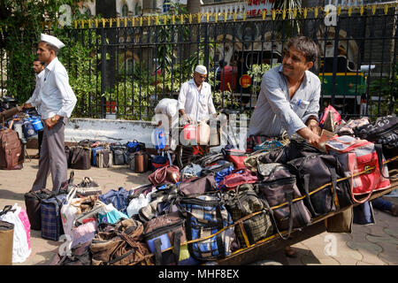 Einige der 5.000 Dabbawalas, in den obligatorischen weißen Gandhi caps Vorbereitung von 130.000 Lunchboxen zu Büros geliefert, jeden Morgen zu liefern gekleidet und nach Hause zurückgekehrt, jeden Nachmittag, 6 Tage die Woche, 51 Wochen im Jahr. Der Dienst bietet Hausmannskost von zu Hause ins Büro geliefert und wieder zurück nach Hause. Der Service ist beansprucht weniger als 1 Fehler in 6 Million Lieferungen zu machen. Mumbai, Indien. Foto von Mike Abrahams Stockfoto