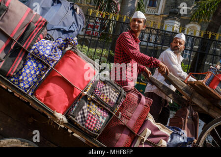 Einige der 5.000 Dabbawalas, in den obligatorischen weißen Gandhi caps Vorbereitung von 130.000 Lunchboxen zu Büros geliefert, jeden Morgen zu liefern gekleidet und nach Hause zurückgekehrt, jeden Nachmittag, 6 Tage die Woche, 51 Wochen im Jahr. Der Dienst bietet Hausmannskost von zu Hause ins Büro geliefert und wieder zurück nach Hause. Der Service ist beansprucht weniger als 1 Fehler in 6 Million Lieferungen zu machen. Mumbai, Indien. Foto von Mike Abrahams Stockfoto