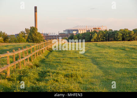 Ein Zaun in Newcastle-Upon-Tyne Town Moor Park in Richtung der eindrucksvolle Struktur von St James Park Fußball Stadion auftauchen groß in der backgro Stockfoto