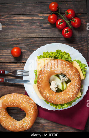 Vollkornbrot Bagel mit grünem Pesto, frisches Gemüse, Käse, Tomaten und Birne. Stockfoto