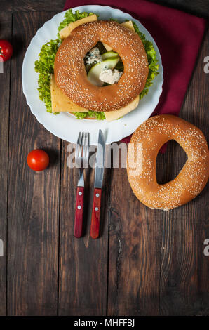 Vollkornbrot Bagel mit grünem Pesto, frisches Gemüse, Käse, Tomaten und Birne. Stockfoto