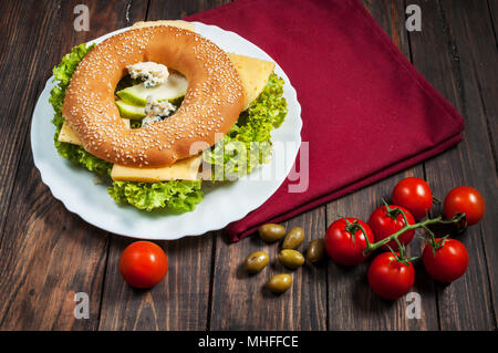 Vollkornbrot Bagel mit grünem Pesto, frisches Gemüse, Käse, Tomaten und Birne. Stockfoto