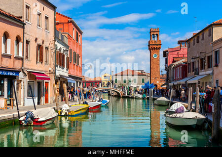 Menschen zu Fuß schmalen Kanal mit Booten unter alten bunten Häuser von Murano - berühmte Insel in der Lagune von Venedig. Stockfoto