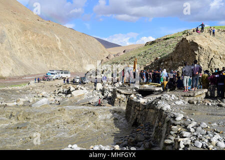Bagger reinigen das Erdrutschgebiet und Einheimische und Touristen beobachten und helfen, den Weg in leh ladakh kaschmir Indien frei zu machen Stockfoto