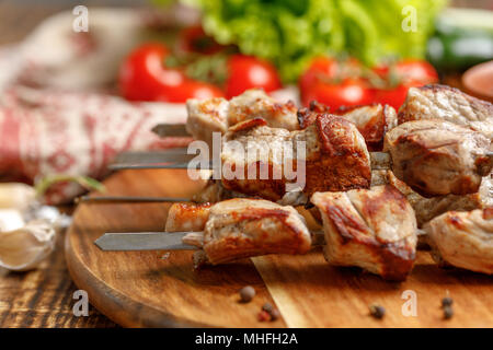 Saftige Kebabs aus Schwein am Spieß. Still-life auf einem hölzernen Hintergrund. Stockfoto