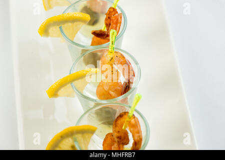 Einzelne Cocktail Shrimps Shot Gläser mit köstlichen hausgemachten Zahnstein pikanter Sauce mit Petersilie Blatt für das Weihnachtsessen oder cocktailparty eingerichtet, bokeh Hintergrund, Nahaufnahme Stockfoto