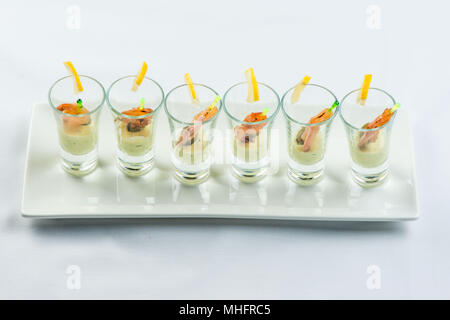 Einzelne Cocktail Shrimps Shot Gläser mit köstlichen hausgemachten Zahnstein pikanter Sauce mit Petersilie Blatt für das Weihnachtsessen oder cocktailparty eingerichtet, bokeh Hintergrund, Nahaufnahme Stockfoto