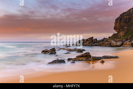 Weich und felsige Küstenlandschaft - Erfassung der Sonnenaufgang von Ettalong Beach an der Central Coast, NSW, Australien. Stockfoto