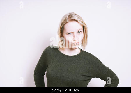 Skeptisch junge Frau Grimassen machen ein lustiges Gesicht Stockfoto