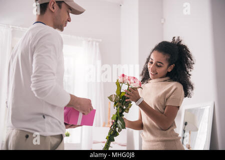 Gerne fröhliche Frau mit Blumen Stockfoto