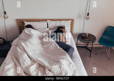 Ansicht von oben der Paare schlafen Rücken an Rücken im Bett. Mann und Frau schlafen im Schlafzimmer zu Hause. Stockfoto