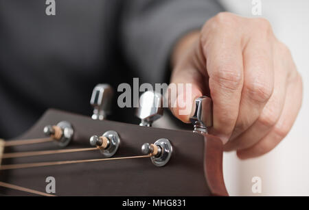 Close Up's Frau Hände Einstellen der Akustik Gitarre. Stockfoto