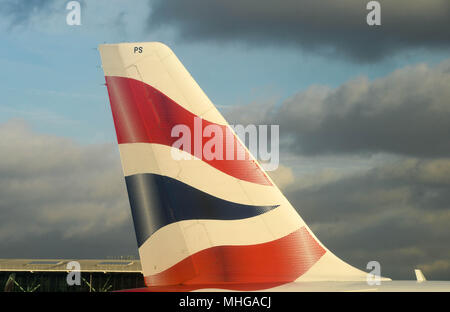 Nahaufnahme der Schwanz einer British Airways Airbus Passenger Jet am Flughafen London Heathrow gegen einen dunklen bewölkter Himmel Stockfoto