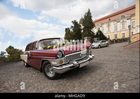 Uschhorod, Ukraine - 18. April 2015: Alte, gewaschen, poliert gut aussehende retrocar stehen auf der Straße. Farbig in Rot und Weiß. Schöne Linien, helle, gesättigte Farben. Gemütliches, nettes Straße Stockfoto