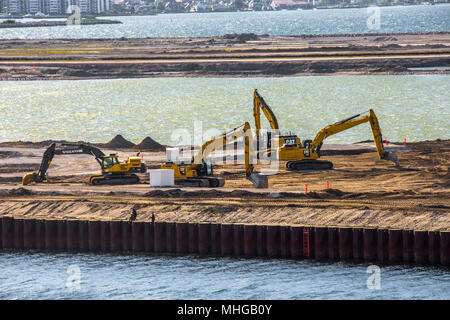 Vier große gelbe mechanische JCB Bagger arbeiten an der Kopenhagener Docks Stockfoto