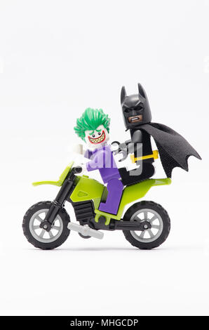 Mini Abbildung von Joker mit Batman auf ihrem Rücken reiten Dirt Bike. Lego Minifiguren sind von der Lego Gruppe hergestellt. Stockfoto