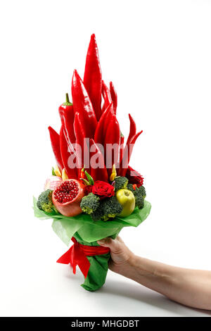 Wunderschönen Blumenstrauß aus Paprika, Brokkoli, Äpfel und andere Früchte und Gemüse in der Hand als ein Geschenk auf weißem Hintergrund Stockfoto