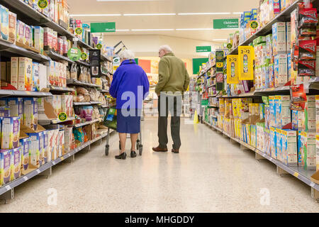 Ältere Paare shopping in die Gänge von Morrisons Supermarkt in Stockton, Heide, in der Nähe von Warrington, Cheshire, England, Großbritannien am 30. April 2018 Stockfoto