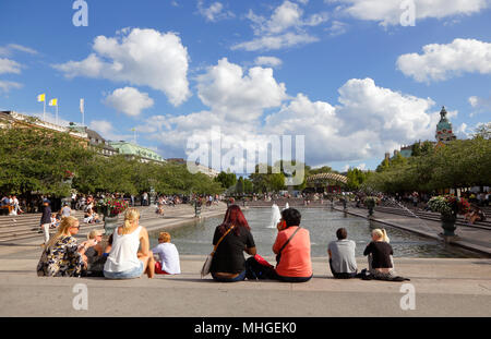 Stockholm, Schweden - 10. Juli 2016: Menschen sitzen neben dem fontain im sonnigen Kungstradgarden Park. Stockfoto