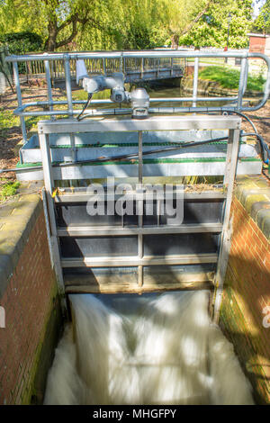 Ein metall Gatter mit dem Wasser aus dem Fluss Great Ouse durch an der Bedford sprudeln Stockfoto