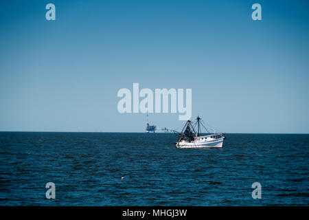 Shrimp trawlers Kreuzfahrten auf Mobile Bay mit Erdgas Plattformen im Hintergrund. Stockfoto