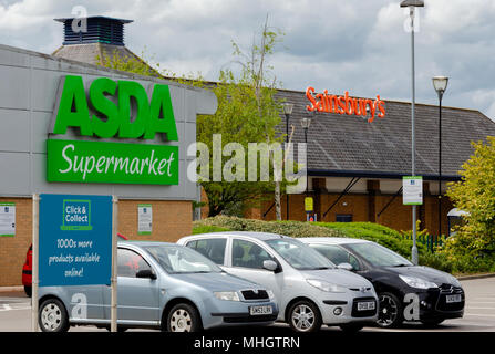 Feuerstein, Wales, 1. Mai 2018. Asda Kunden in ihren Autos Parkplatz im Schatten der Sainsbury Supermarkt geparkt unangenehm in der Nähe. Sainsbury und Asda haben in ihren ersten Bemerkungen über ihre mögliche Fusion vorgeschlagen, dass es keine standortschließungen geben wird. Quelle: John David Fotografie/Alamy leben Nachrichten Stockfoto