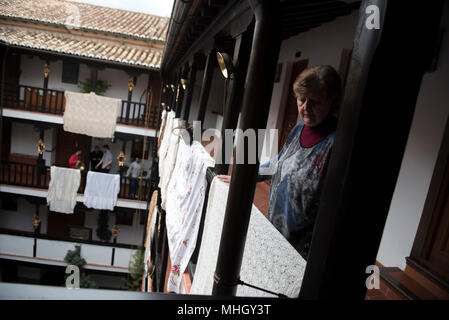 Eine Frau mit einem Schal ziert die 'Corrala de Santiago" für die "ia de la Cruz". "El Día de la Cruz" oder "Día de las Cruces" ist eines der schönsten Feste in Granada. Jeder dritte Mai viele Straßen, Plätze und Terrassen zeigen Altäre mit Kreuzen geschmückt mit Blumen zum Heiligen Kreuz zu gedenken. Stockfoto