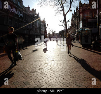 Reading, Großbritannien - 20 April 2018: Käufer silhouettted in die untergehende Sonne auf der Broad Street Stockfoto