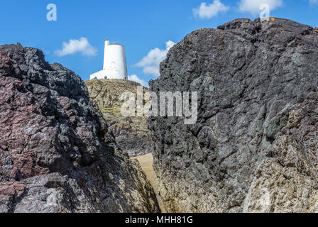 Eine Ansicht von Twr Mawr Leuchtturm auf llanddwyn Island, Anglesey, Nordwales durch eine Lücke in der Lava Säulen. Stockfoto