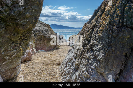 Der Blick durch die Lava Säulen an der Spitze des Llanddwyn Island auf Anglesey, Nordwales. Stockfoto