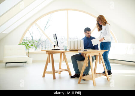 Die volle Länge der junge Unternehmer sitzen vor dem Laptop und Beratung mit Vertrieb Frau über das neue Projekt. Stockfoto