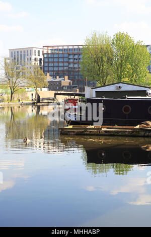 Die Boote auf der Regent's Canal durch Gasspeicher Park, Kings Cross, mit den neuen Gebäuden auf Waren Weg, London, UK Stockfoto