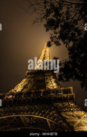 Der Eiffelturm bei Nacht mit seinen Gipfel im Nebel/Nebel/Wolken Stockfoto