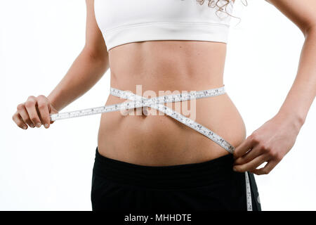 junge Frau Diäten und Gewichtsverlust messen Taille mit Klebeband auf weißem Hintergrund zu betrachten Stockfoto