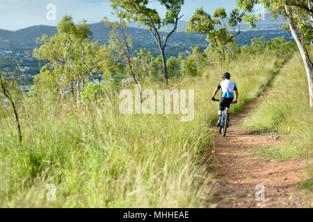 Männliche Fahrrad Reiter auf einem Mountainbike Bergabfahren auf einer Schotterpiste, Mount Stuart Wanderwege, Townsville, Queensland, Australien Stockfoto