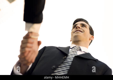 Attraktiver Geschäftsmann und Geschäftsfrau Händeschütteln außerhalb des Bürogebäudes. Paar arbeiten. Stockfoto
