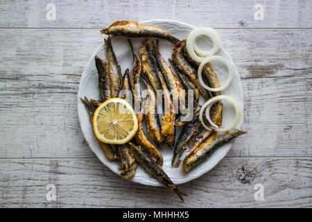 Türkische Hamsi Tava/Frittierte Sardellen auf weißem Holz- Oberfläche. Stockfoto