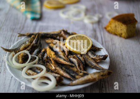 Türkische Hamsi Tava mit Cornbread/Frittierte Sardellen auf weißem Holz- Oberfläche. Stockfoto