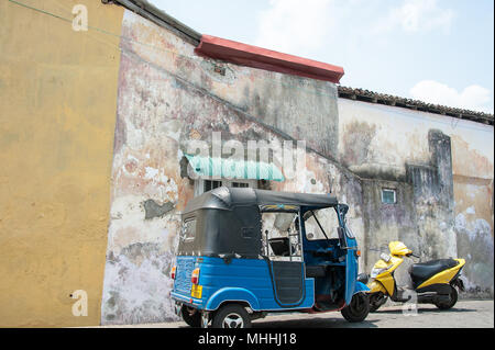 Galle, Sri Lanka: Galle Fort Straßenbild. Typische Architektur, bunte Stuck Wand, mit Tuk-Tuk und Motorroller im Vordergrund Stockfoto