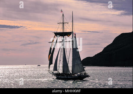 Atemberaubenden Sonnenuntergang, San Diego Bay mit der Tall Ship Calfornian Silhouette gegen einen silbrigen Meer. Elegante Masten, die von der Sonne beleuchtet. Stockfoto