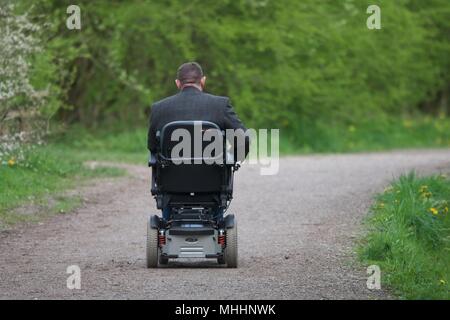 Ein Mann in einem elektrischen Rollstuhl fährt die Sett Valley Trail in neuen Mühlen, Derbyshire. Stockfoto