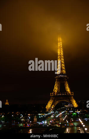 Der Eiffelturm bei Nacht mit seinen Gipfel im Nebel/Nebel/Wolken Stockfoto