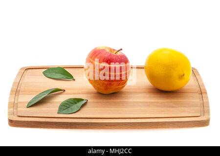 Apple schmackhaft, frisch und saftig mit grünen Blättern und Zitrone auf einem Schneidebrett aus Holz. Stockfoto