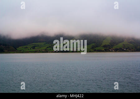 Misty See und grüne Felder Landschaft Stockfoto