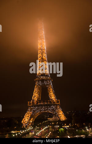 Der Eiffelturm bei Nacht mit seinen Gipfel im Nebel/Nebel/Wolken Stockfoto